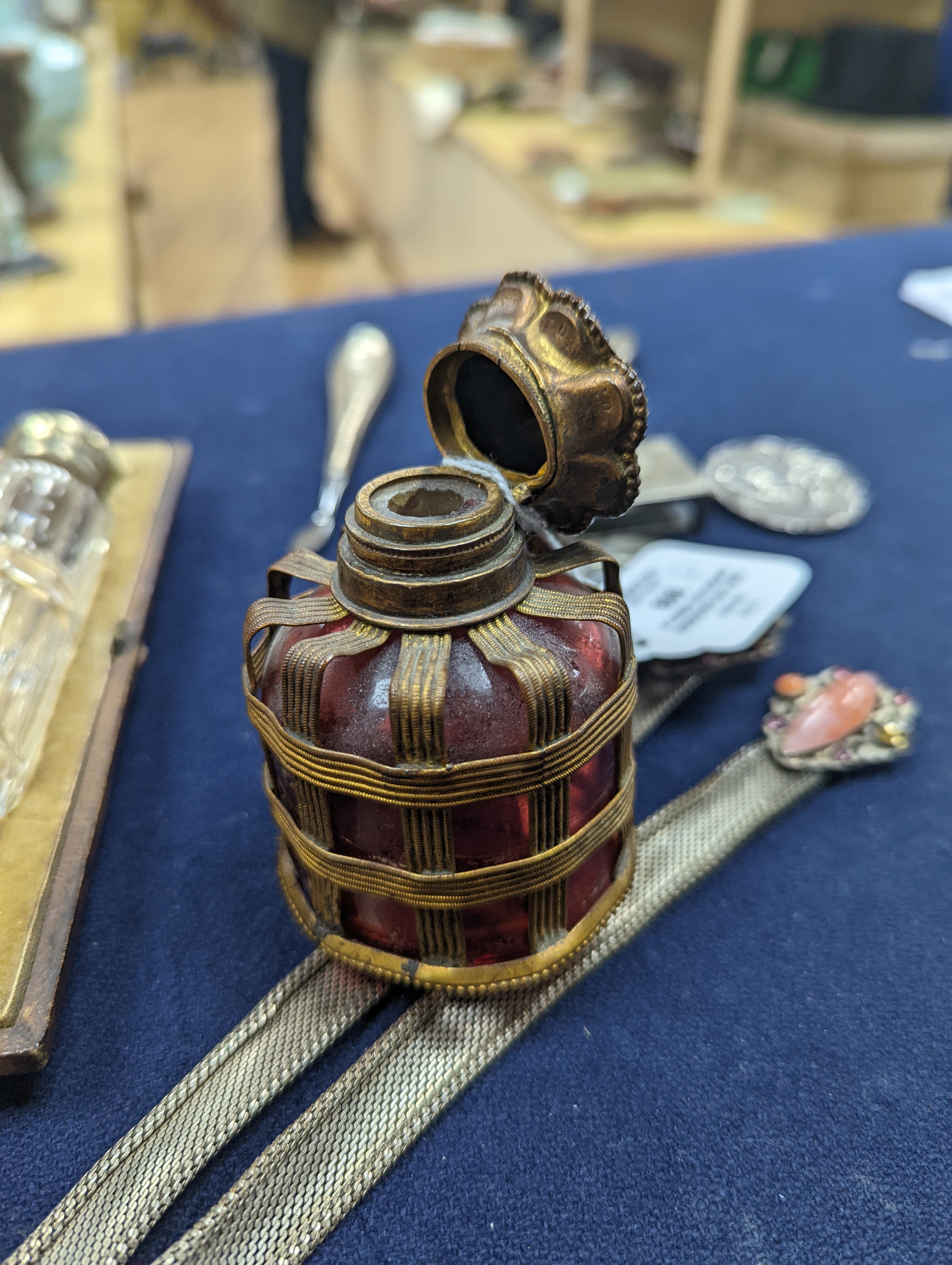 A cased Victorian engraved gilt white metal and coral set double ended scent bottle, 13.4cm, a silver cigar cutter, a belt, a silver buckle, gilt and cranberry perfume bottle, etc.